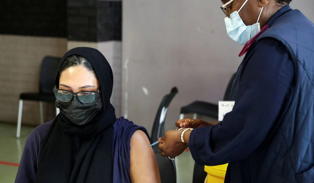 A healthcare worker administers the COVID-19 vaccine to a pregnant woman